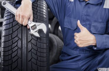 mechanic showing ok gesture with his thumb while holding a wrench